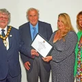 Cllr Mike Best, left, hands a Somerset Council Chair Award to representatives from Chatty Hour Tuesdays, from Lympsham
