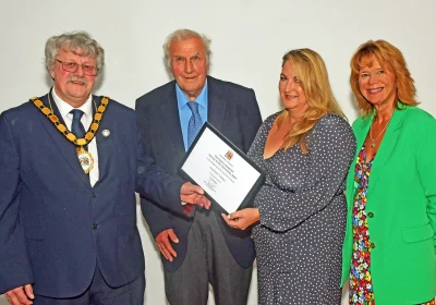 Cllr Mike Best, left, hands a Somerset Council Chair Award to representatives from Chatty Hour Tuesdays, from Lympsham