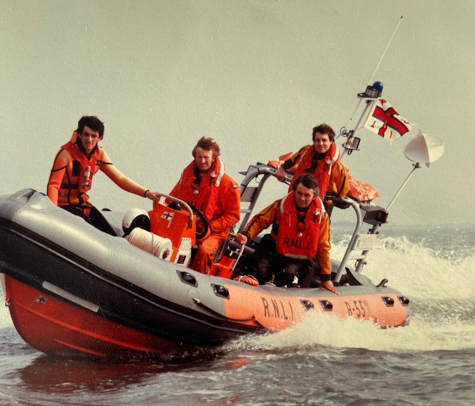 1983 (approximately) Spin perched on the bow of the Atlantic 21(B-557) Lifeboat in his Lifeboat swimmers wetsuit with Julian Morris as helm Picture: West Air Photography