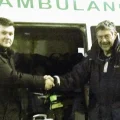 Nich Woolf, right, hands over the ambulance in Ukraine on behalf of FMS