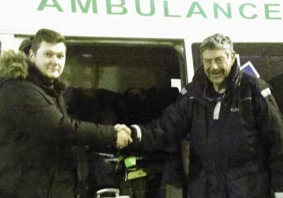 Nich Woolf, right, hands over the ambulance in Ukraine on behalf of FMS