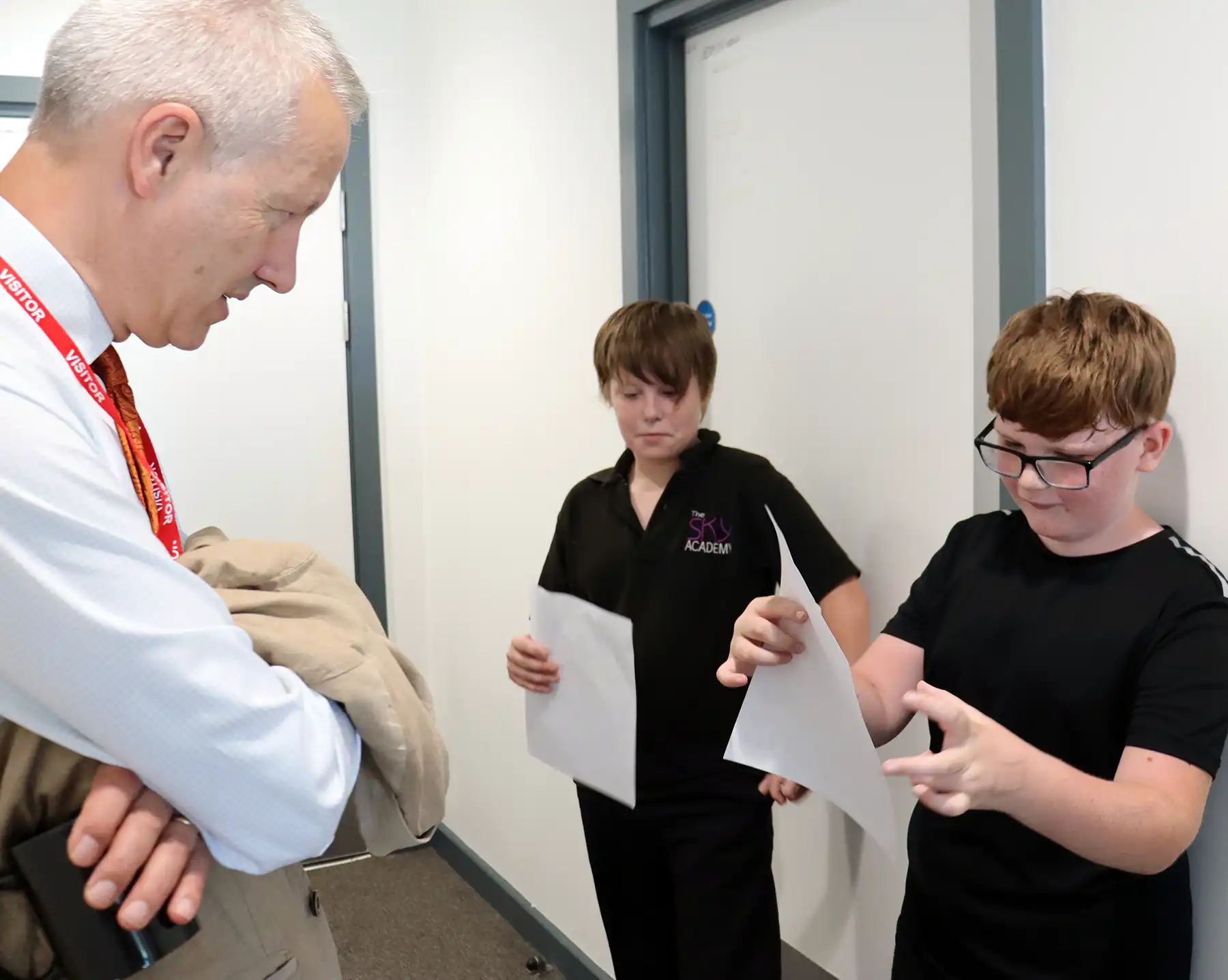 Josh Stalley and George Ives reciting their poems to MP Gideon Amos