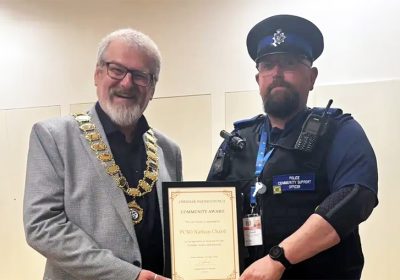 PCSO Nathan Chard, right, receives his award from chair of Cheddar Parish Council, Derek Bradley-Balmer. Picture: Avon & Somerset Police