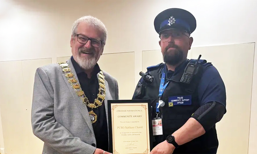 PCSO Nathan Chard, right, receives his award from chair of Cheddar Parish Council, Derek Bradley-Balmer. Picture: Avon & Somerset Police