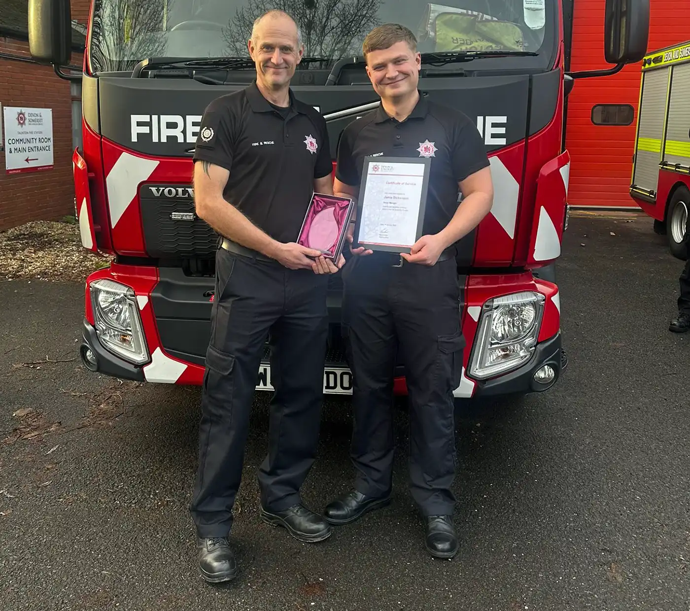 Jamie was presented with his certificate of service and clasp by his son, Jack, who is also a firefighter. Picture: DSFRS